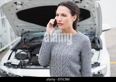 Verärgert Frau am Telefon neben ihr Auto zerlegt Stockfoto