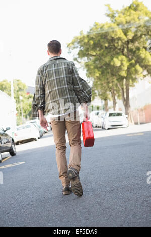 Mann ein aufgeschlüsselt Auto Benzinkanister bringen Stockfoto