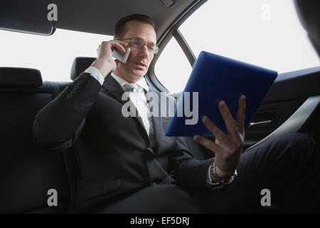 Geschäftsmann am Telefon mit TabletPC Stockfoto