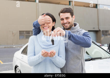 Junger Mann, Freundin mit Neuwagen überraschen Stockfoto