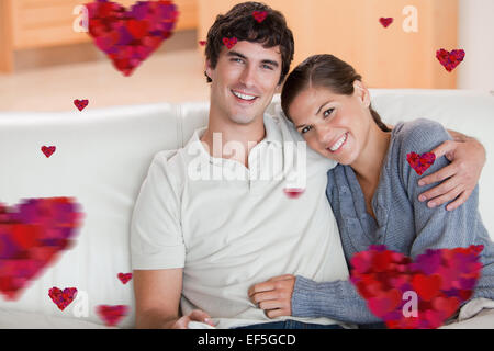Zusammengesetztes Bild der glücklichen Paare genießen ihre Zeit zusammen auf der couch Stockfoto