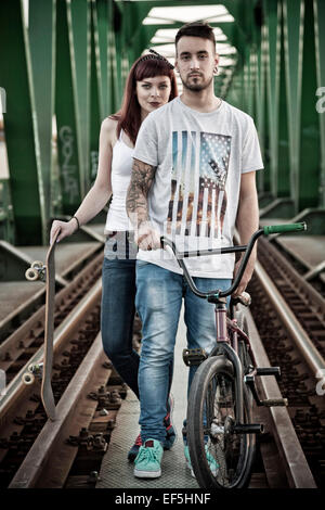 Junges Paar mit Skateboard und BMX Fahrrad im freien Stockfoto