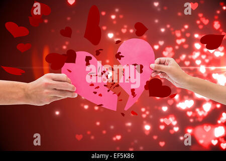 Zusammengesetztes Bild von Händen mit zwei Hälften des gebrochenen Herzens Stockfoto