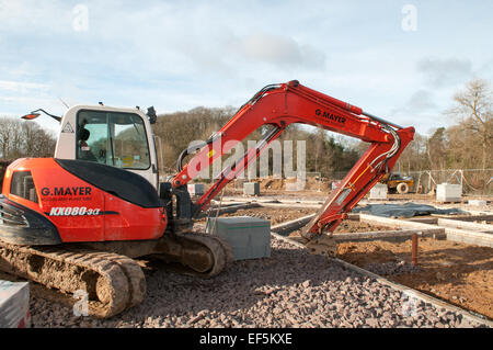 Eine leere Baustelle mit einem Bagger und ein Haufen von Brise Blöcke für Bauherren ein Wohnprojekt zu warten Stockfoto