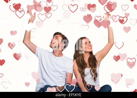 Zusammengesetztes Bild von glücklichen jungen Paar mit erhobenen Händen Stockfoto
