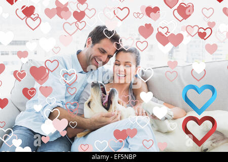 Zusammengesetztes Bild des glücklichen Paares streicheln ihre gelben Labrador auf der couch Stockfoto