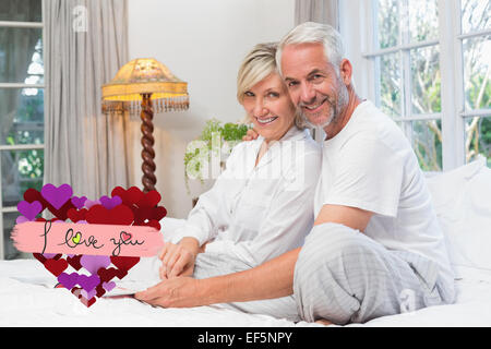 Zusammengesetztes Bild Porträt von einem entspannten glücklich älteres Paar mit Buch im Bett Stockfoto