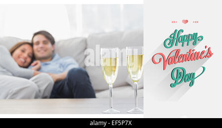 Zusammengesetztes Bild des Paares ruht auf einer Couch mit Kanneluren Champagner Stockfoto