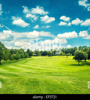 Golfplatz und blauen Wolkenhimmel. Schöne Landschaft mit grünen Rasen. Retro-Stil getönten Bild Stockfoto