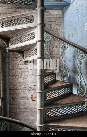 Cilcewydd Mill, Welshpool, Powys, Großbritannien. Eine gusseiserne, feuerfeste Wendeltreppe verläuft von oben nach unten dieser verlassenen viktorianischen Mühle Stockfoto