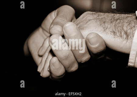 Nahaufnahme eines jungen Mannes an der Hand eines alten Mannes in schwarz / weiß Stockfoto