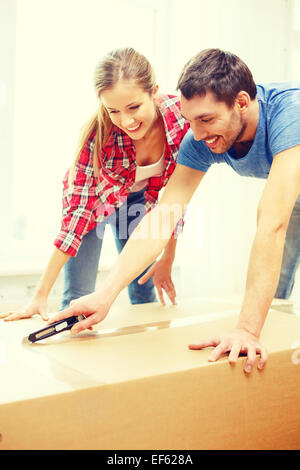 lächelnde paar Eröffnung großer Karton Stockfoto