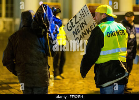 Schwerin, Deutschland. 26. Januar 2015. Ein Anhänger der Anti-Islamischen Bewegung MVgida (Mecklenburg-Vorpommern gegen die Islamisierung des Abendlandes) versucht, einen Kameramann bei einer Demonstration in Schwerin, Deutschland, 26. Januar 2015 zu blockieren. Sie wurden von zahlreichen Gegendemonstrationen erfüllt. Foto: Jens Büttner/Dpa/Alamy Live News Stockfoto