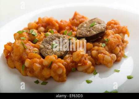 Gebackene Bohnen und Wurst über weiße Platte Stockfoto