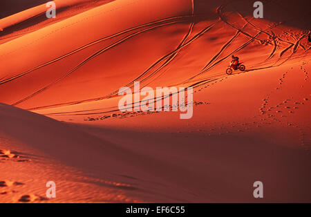 Erg Chebbi.Motorbike auf Sanddünen in der Sahara, in der Nähe von Merzouga bei Sonnenuntergang. Marokko, Nordafrika Stockfoto