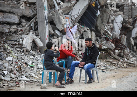 Gaza, Gaza-Stadt. 27. Januar 2015. Palästinenser-Chat in der Nähe von Trümmern ihrer Häuser, die während der 50-Tage israelischen Offensive im Gazastreifen im letzten Juli und August, in Al-Schadschaija Nachbarschaft, östlich von Gaza-Stadt, am 27. Januar 2015 zerstört wurden. Das UNO-Hilfswerk und Works Agency (UNRWA) beschlossen am Dienstag, Unterstützung der palästinensischen Familien, deren Häuser zerstört wurden, in der israelischen Offensive gegen den Gaza-Streifen im Juli und August letztes Jahr. © Wissam Nassar/Xinhua/Alamy Live-Nachrichten Stockfoto