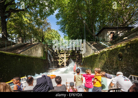 Canal Saint Martin Paris. Ein Tourist Grachtenfahrt Boot in einem Schloss mit Familie, Kinder beobachten, das Sprudeln im Wasser genießen. Stockfoto