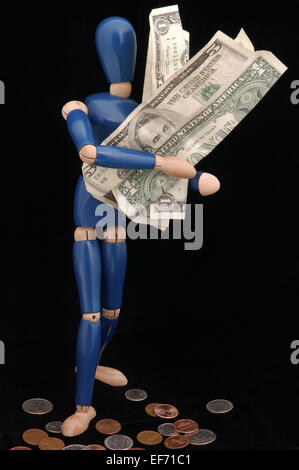 Weibliche Schaufensterpuppe aus Holz Figur stehend mit einem Arm voller Geld. Stockfoto