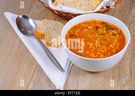 Hausgemachte vegetarische Minestrone-Suppe mit Brot serviert. Stockfoto