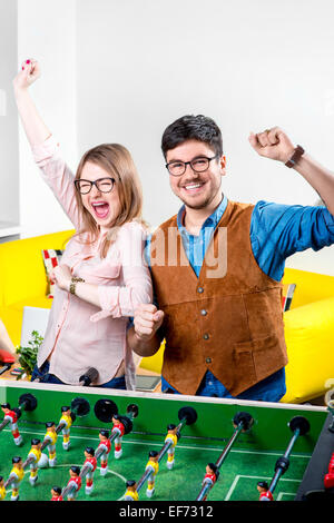 Freunde spielen Tischfußball Stockfoto