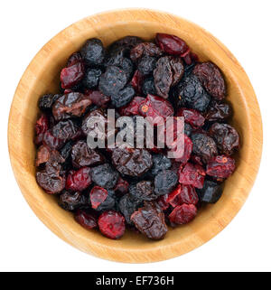 Getrocknete Mischung Beeren Früchte. Getrocknete Cranberries, Rosinen, Sauerkirschen, Heidelbeeren in Holzschale isoliert auf weißem Hintergrund. An Stockfoto