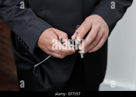 Ein Mann schaut auf seiner Hochzeit in einem Anzug für Uhr Stockfoto