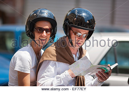 junges Paar in Rom auf der Suche nach dem Weg auf Roller Stockfoto