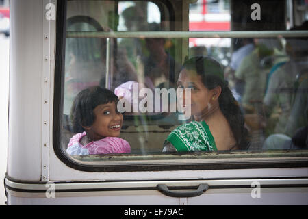 SRI LANKA-MUTTER UND TOCHTER DURCH BUSFENSTER LÄCHELN Stockfoto