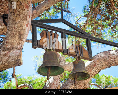Zwei alte Glocken in das orthodoxe Kloster Preveli, Kreta, Griechenland. Befindet sich auf den Zweigen des alten Baumes. Stockfoto