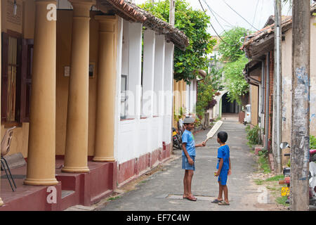 JUNGS SPIELEN CRICKET IN KOLONIALEN STRAßE IN GALLE FORT Stockfoto