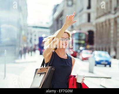 Geschäftsfrau hagelt Taxi in die Stadt Stockfoto