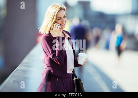 Geschäftsfrau, reden über Handy auf städtische Brücke Stockfoto