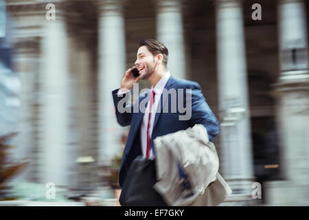 Verschwommene Sicht auf Geschäftsmann reden über Handy in Stadt Stockfoto