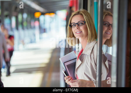 Geschäftsfrau, die lächelnd in Zug Tür Stockfoto