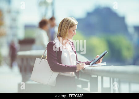 Geschäftsfrau mit digital-Tablette im städtischen waterfront Stockfoto