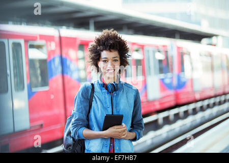 Lächelnde Frau im Bahnhof Stockfoto