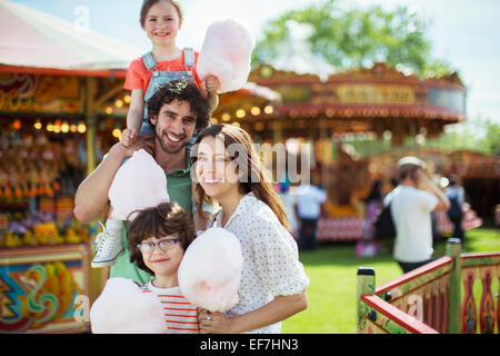 Porträt von fröhlichen Familienholding rosa Zuckerwatte im Vergnügungspark Stockfoto