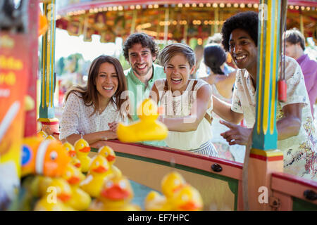 Gruppe von Freunden, die Spaß mit Angelspiel im Vergnügungspark Stockfoto