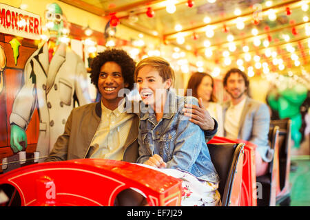 Mann umarmt Freundin auf Geisterbahn Stockfoto