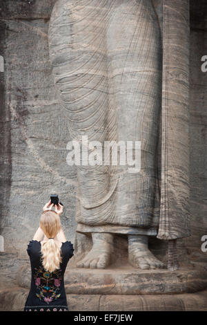 TOURISTISCHEN SNAP AUFNAHME DER RIESIGEN BUDDHA-STATUE AUF LOTUS SOCKEL; GAL VIHARA FELSENTEMPEL Stockfoto