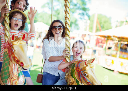 Familie auf Karussell im Vergnügungspark Stockfoto