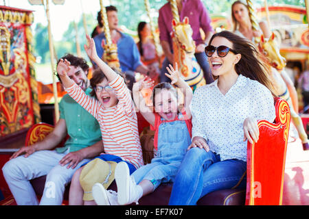 Familie auf Karussell im Vergnügungspark Stockfoto