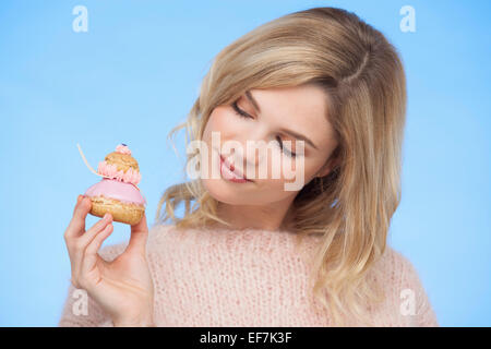 Nahaufnahme einer schönen Frau hält eine französische Erdbeere religieuse Stockfoto