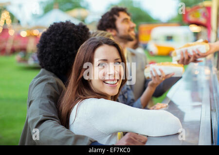 Menschen kaufen Hotdogs in Essen stehen im Freizeitpark Stockfoto