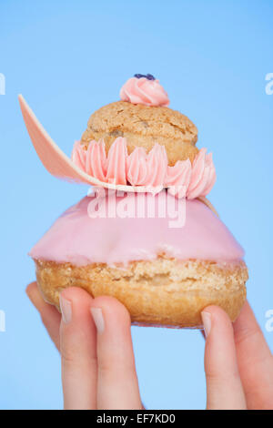 Nahaufnahme einer Frau Hand hält eine französische Erdbeere religieuse Stockfoto
