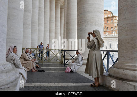 Eine Nonne, fotografieren ihr Nonne Freunde durch die Spalten der Kolonnade in St.-Peter Platzes, Vatikanstadt, Rom, Italien. Stockfoto