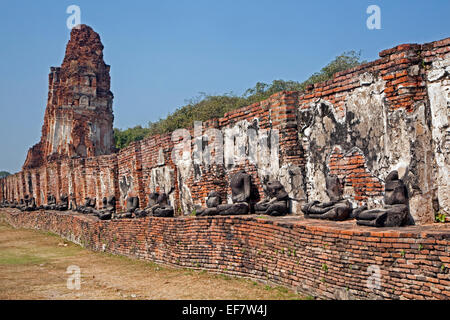 Ruine des buddhistischen Stupa mit Reihe von gebrochenen Buddhastatuen im Wat Mahathat in Ayutthaya Historical Park, Thailand Stockfoto