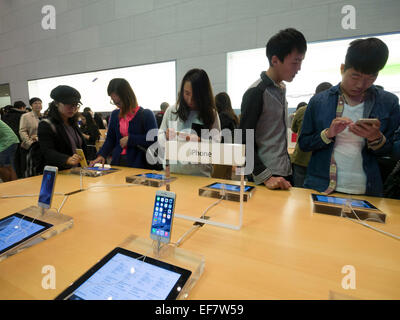 Kunden surfen Apple iPhones im Apple Store befindet sich an der Nanjing Road in Shanghai, China Stockfoto