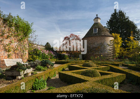 Die geometrischen Formen der Box Hedge-Parterre und c.1685 Taubenschlag im ummauerten Garten Rousham House im Frühherbst, Oxfordshire, England Stockfoto