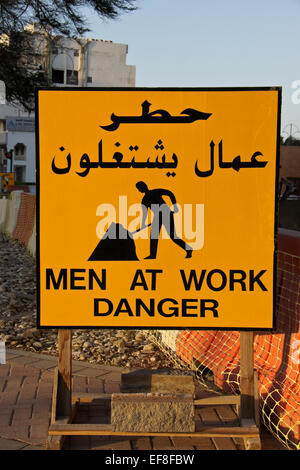 "Men at Work" zu unterzeichnen, in Englisch und Arabisch Stockfoto